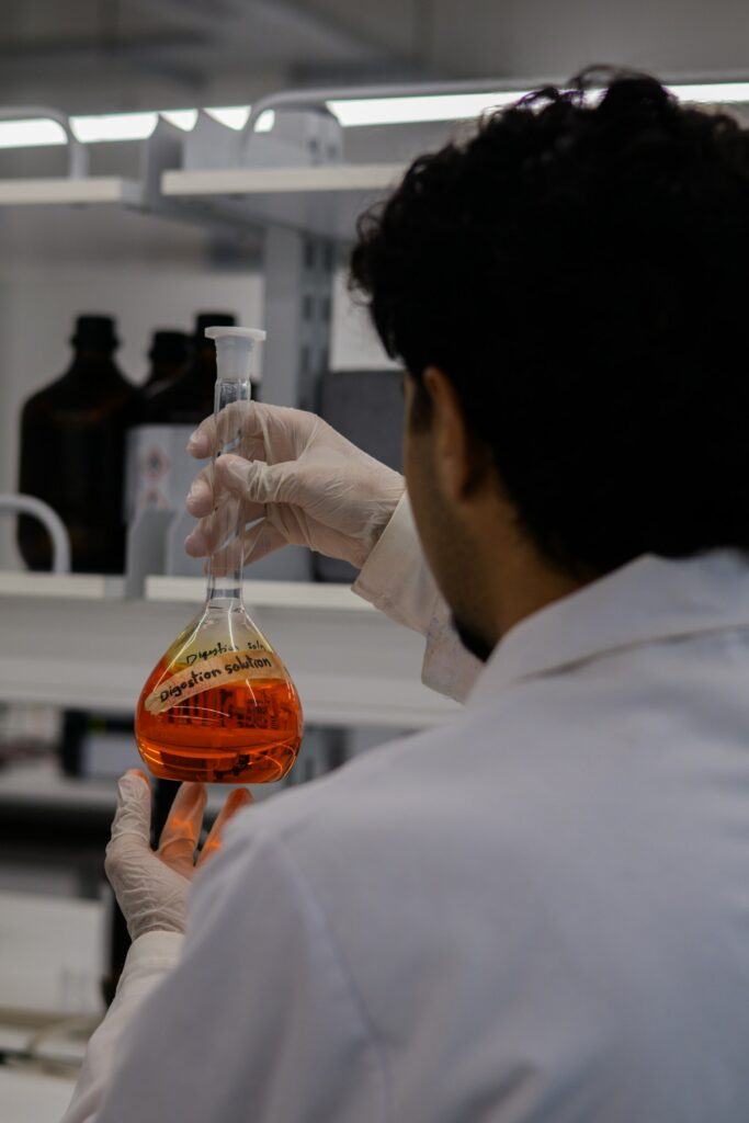 Researcher holding a flask of culture medium in a laboratory